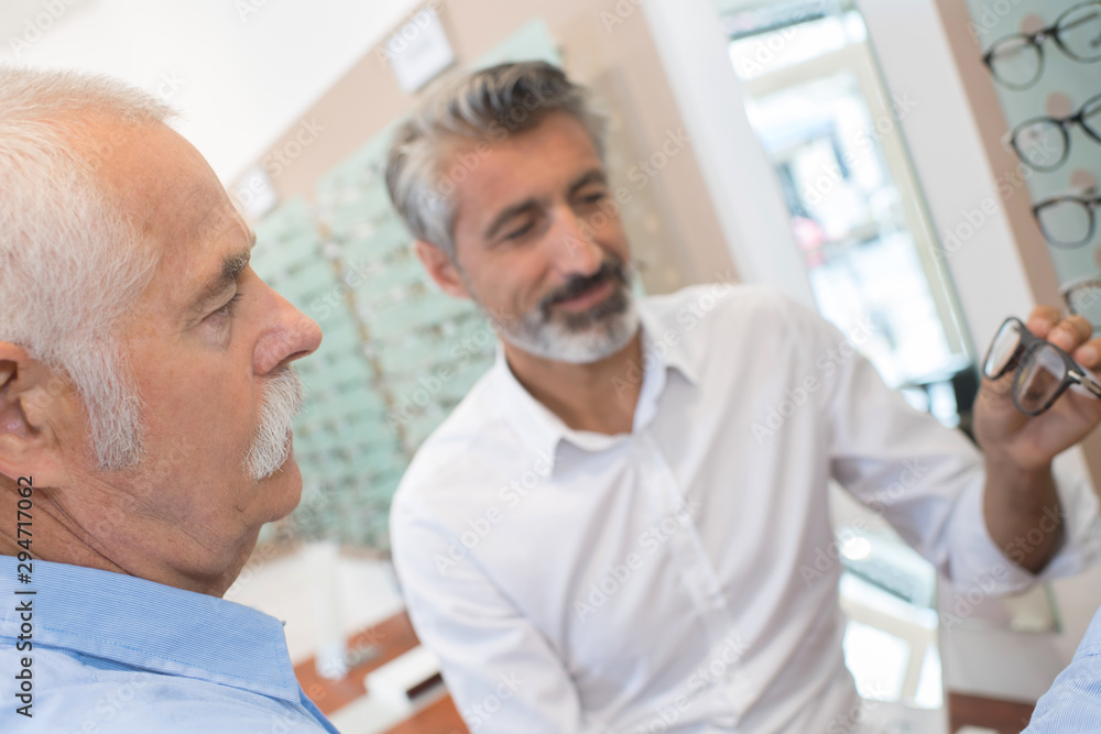 Fototapeta premium optician showing the patient a pair of eyeglasses