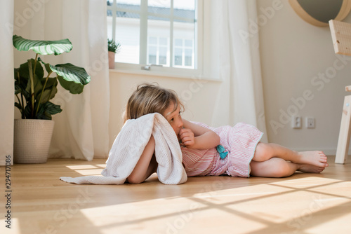 Young girl holing her blanket and sucking her thumb