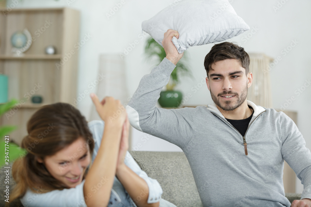 Fototapeta premium picture showing happy couple having pillow fight