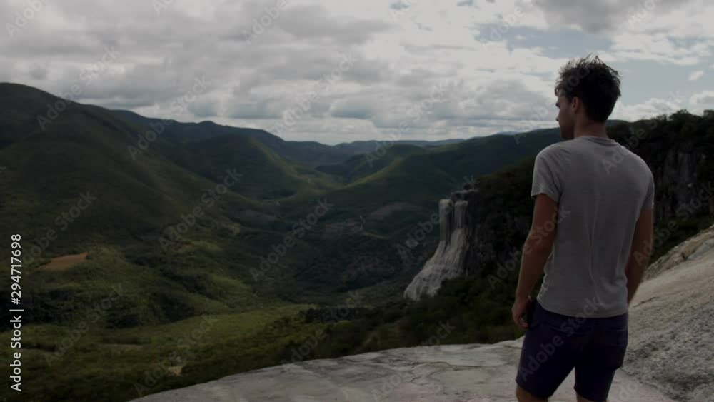 SLOW MOTION - Over the shoulder shot tracking tourist walking to edge of Hierve El Agua Rock Pool in Oaxaca, Mexico SLOW MOTION - Over the shoulder shot tracking tourist walking to edge of Hierve El Agua Rock Pool in Oaxaca, Mexico