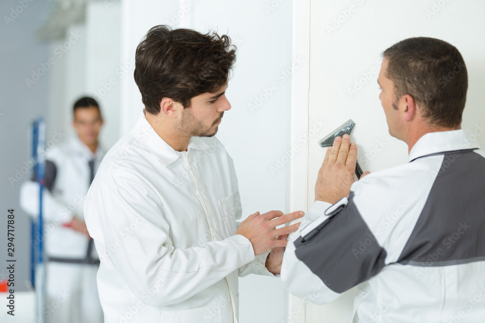 young apprentice sanding wall indoors young apprentice sanding wall indoors
