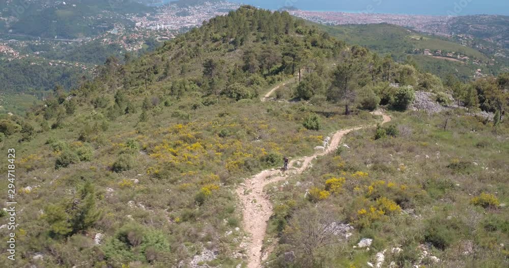 Aerial view of mountain biker riding on arduous path on Mont Chauve, France. Aerial view of mountain biker riding on arduous path on Mont Chauve, France.