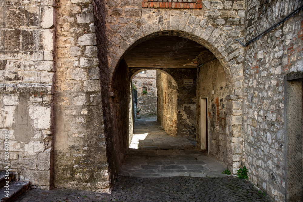 Narrow street passing through stone arches in the medieval town of Roccalbegna, in the Grosseto Maremma.