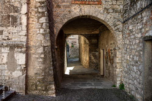 Narrow street passing through stone arches in the medieval town of Roccalbegna  in the Grosseto Maremma.