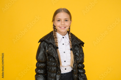 Keep her warm and dry whatever the weather. Happy child on yellow background. Autumn look of little girl child. Fashion child smile in casual style. Cute small child smiling with long blond hair
