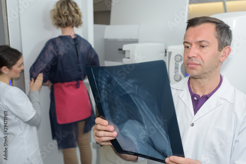 female having xray in standing position doctor studying results