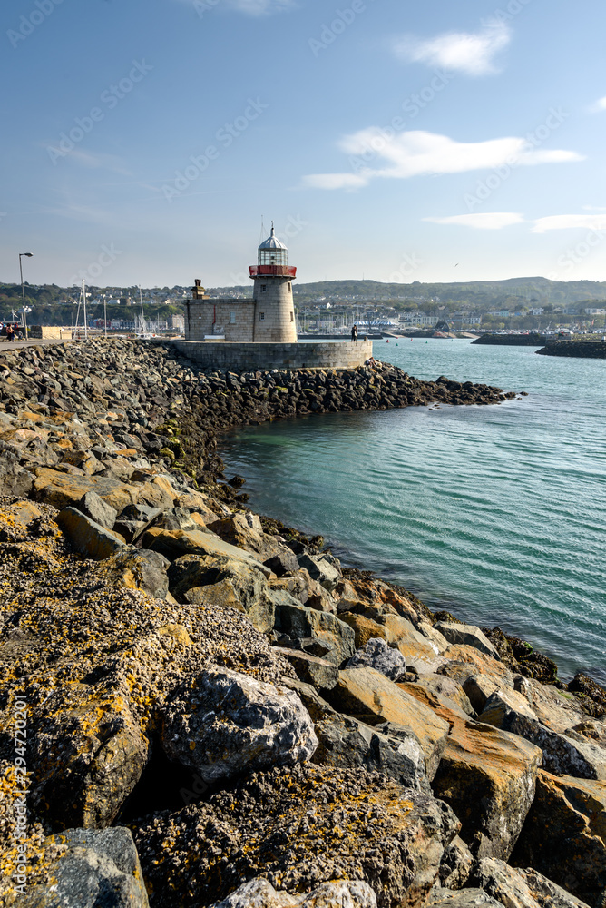 A view of Howth Harbour Lighthouse along  the cold choppy water.