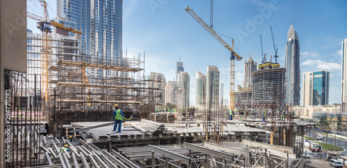 Laborers working on modern constraction site works in Dubai. Fast urban development consept. photo