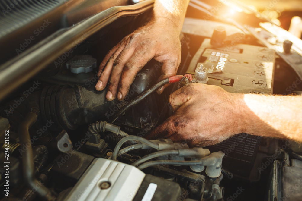 Close-up of mechanic repairing a car without gloves. Close-up of mechanic repairing a car without gloves.