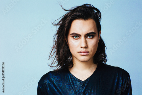 Portrait of a young man with  make up and long hair in studio photo
