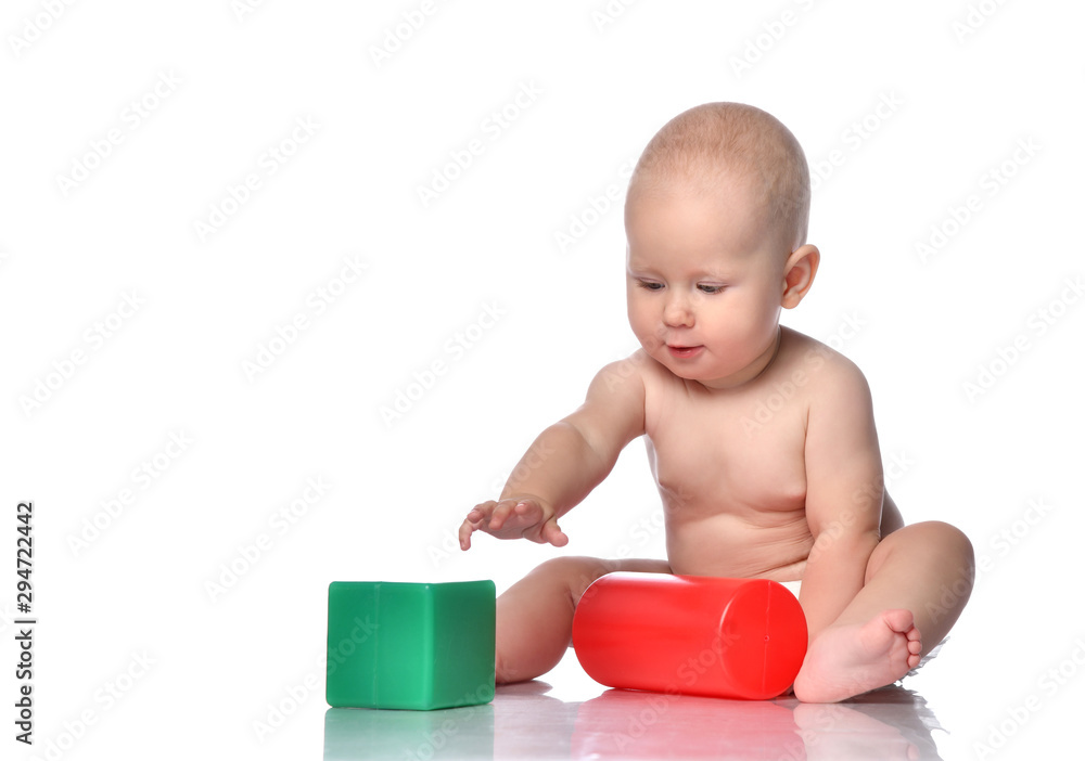 Infant child baby toddler sitting in diaper with green red educational brick toy playing Infant child baby toddler sitting in diaper with green red educational brick toy playing