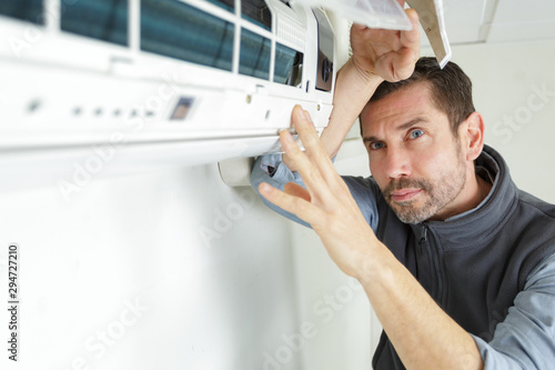 male repairman connecting air conditioner © auremar