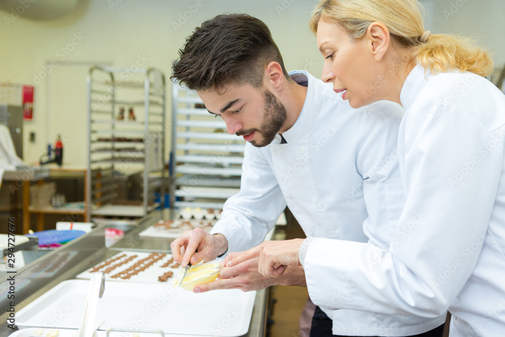 Obraz premium female and male chefs hold bowls with butter