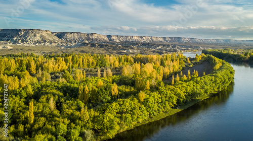 Aerial view of a valley in autumn. The yellow tone is observed in the vegetation. There are big mountains cliff behind. General Roca, Río Negro - Patagonia Argentina photo