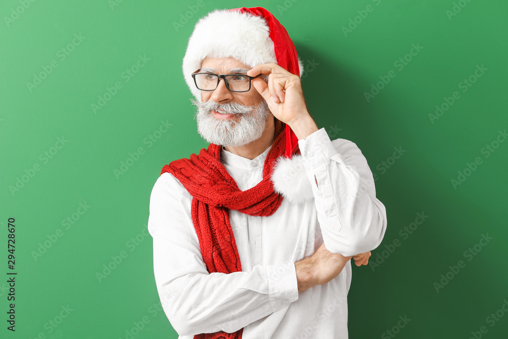 Naklejka premium Portrait of stylish Santa Claus on color background