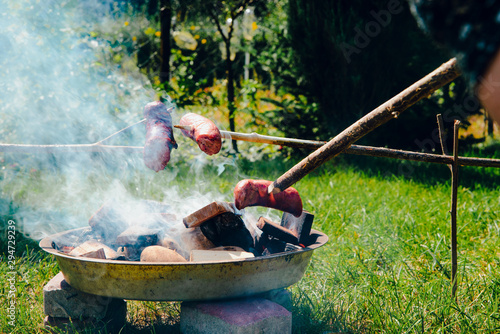 Roasting sausages on the fire. The concept of spending free time outdoors. Lighting a bonfire made of wood. Safe lighting a bonfire, roasting sausages, making a barbecue. Fire. photo