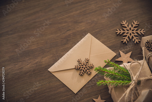 Christmas season. Blank envelope with wooden snowflake on the rustic table