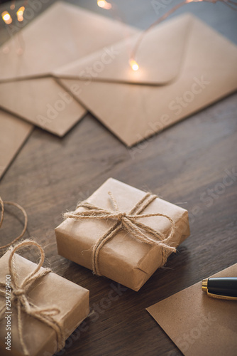 Christmas season. Gift boxes with envelopes laying on the rustic table