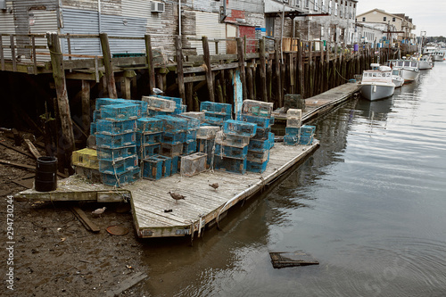Commercial fishing wharf with stacks of lobster traps in the Old Port Harbor district of Portland, Maine.  