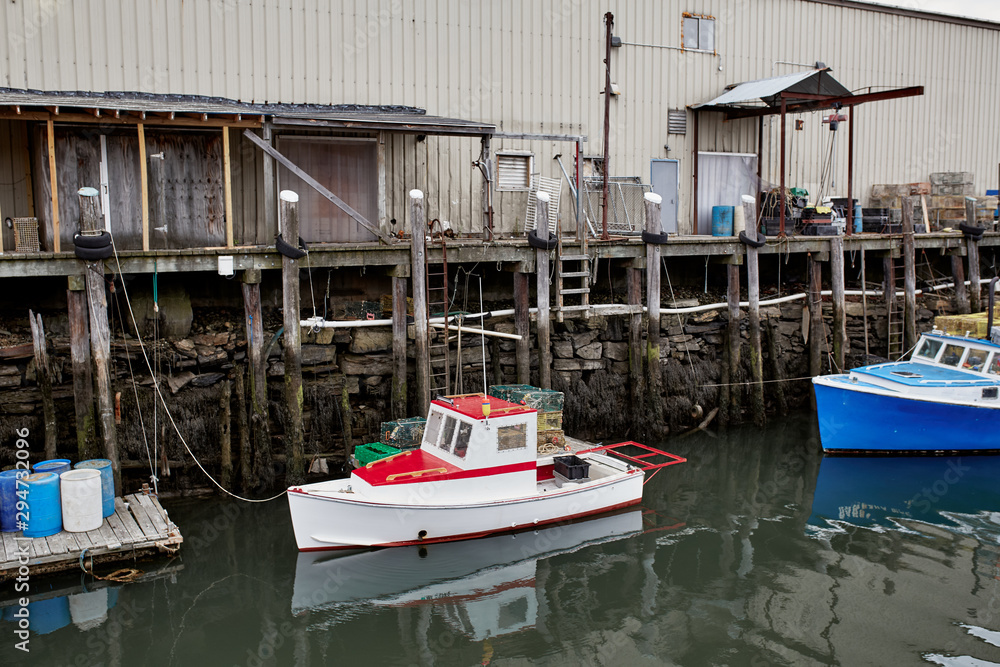 Fototapeta premium Commercial fishing wharf with stacks of lobster traps in the Old Port Harbor district of Portland, Maine. 