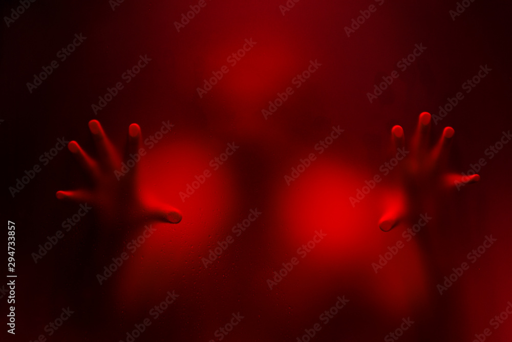 Obraz premium Creepy man holding the frosted glass with two hands.