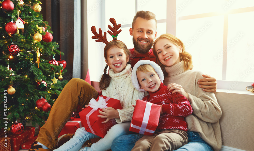 happy family with gifts near Christmas tree at home. happy family with gifts near Christmas tree at home.