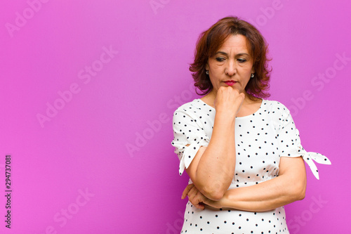 Fotografie middle age woman feeling serious, thoughtful and concerned, staring sideways wit