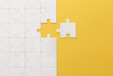 top view of white jigsaw puzzle on yellow background