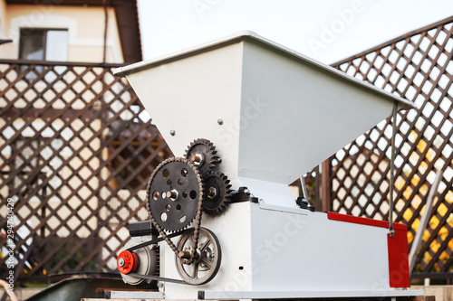 Automatic metal grape crusher for pressing grapes to make wine. Small business concept. Winemaking process. photo