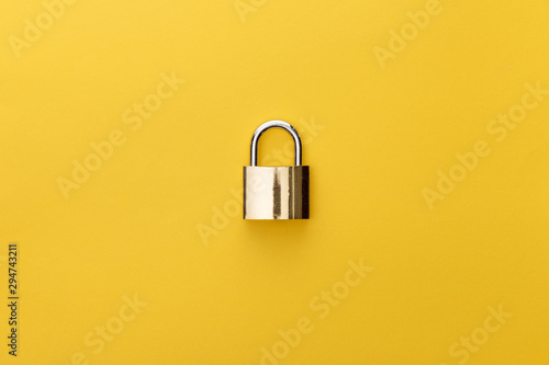 top view of metal padlock on yellow background photo