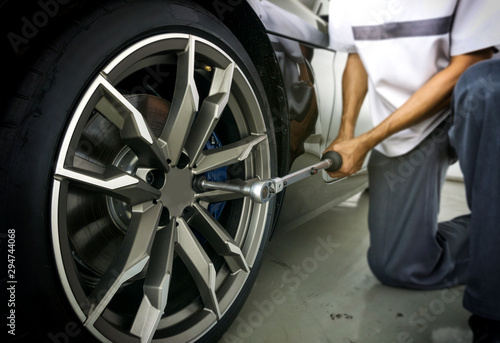Auto mechanic using Torque wrench to inspection the wheel nuts for safety in travel in mechanics garage. Car repair center.
