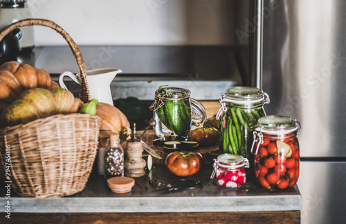 Autumn vegetable pickling and canning. Fresh ingredients and glass jars with homemade vegetables preserves on kitchen counter, close-up. Healthy organic fermented food concept photo