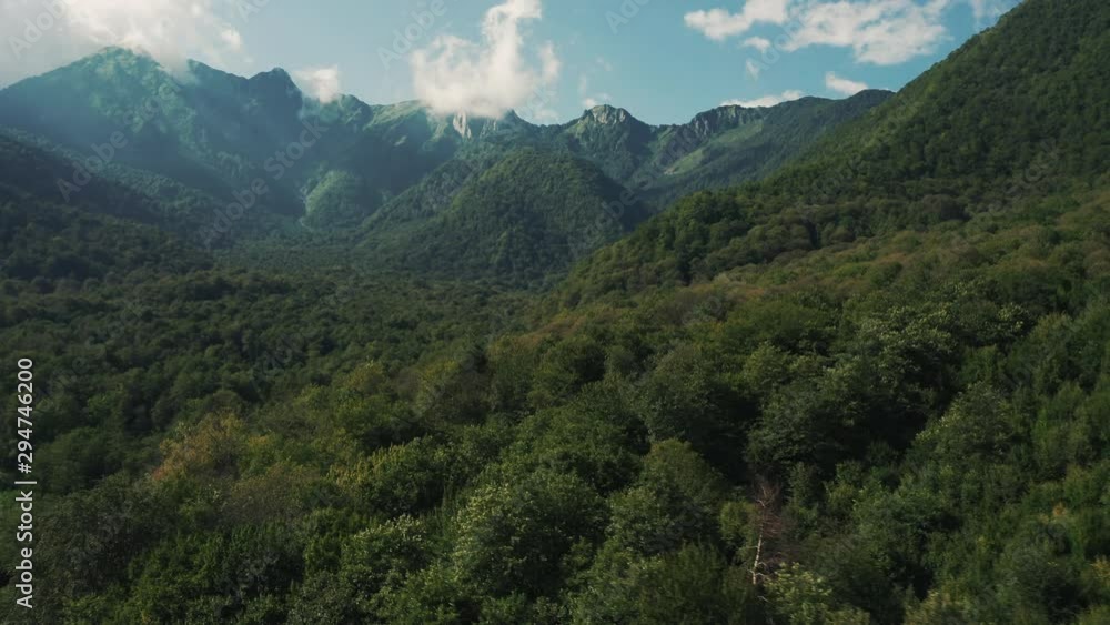 Aerial view of Caucasus mountain ridge; Achishkho mount on background; cloudy summer day in Krasnaya Polyana village; deep mixed forest and protected national park; Russian resort of Black sea Aerial view of Caucasus mountain ridge; Achishkho mount on background; cloudy summer day in Krasnaya Polyana village; deep mixed forest and protected national park; Russian resort of Black sea