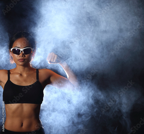 Asian Tan Skin Sport Girl in Fog Smoke Dark background environment Blue color, studio lighting, concept woman can do good health, copy space