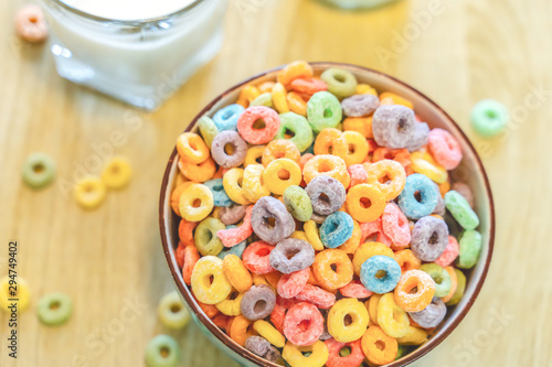 Bowl of colorful children's cereal and milk isolated on wood table with Text space
