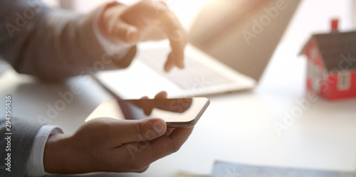 Close-up view of professional businessman holding horizontal smartphone