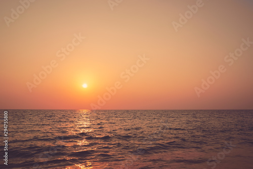 Tropical beach with smooth wave and sunset sky abstract background.
