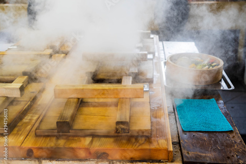 Traditional Japanese wooden Hot steam cooking, hot spring energy cooking good for health called Jigoku mushi kannawa , can steam many kind of food, vegetables, seafood, pork , at Beppu, Oita Japan. photo