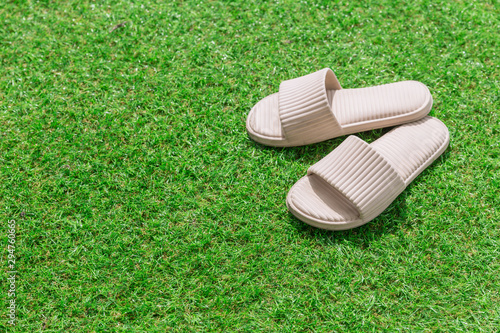 White Sandal or Slippers place on green grass with copy space for text.