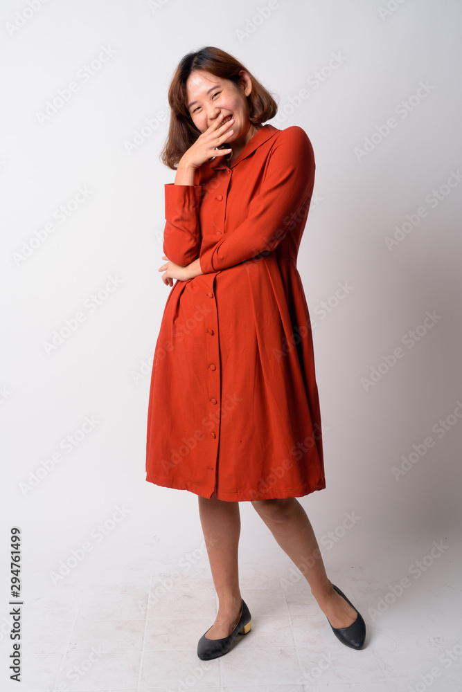 Full body shot of happy beautiful Asian woman laughing Full body shot of happy beautiful Asian woman laughing