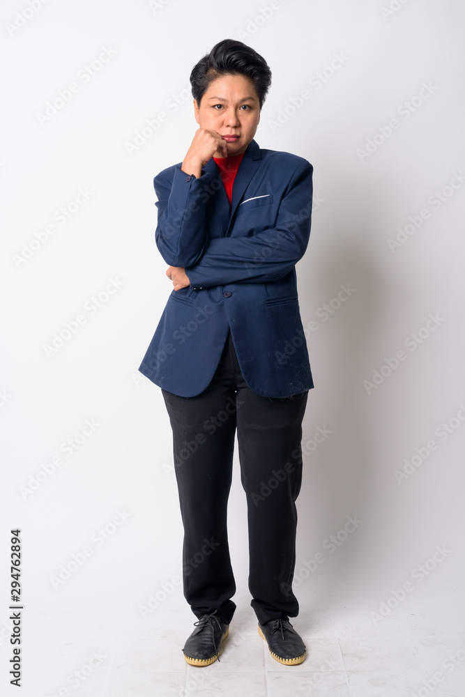 Full body shot of angry mature Asian businesswoman thinking Full body shot of angry mature Asian businesswoman thinking