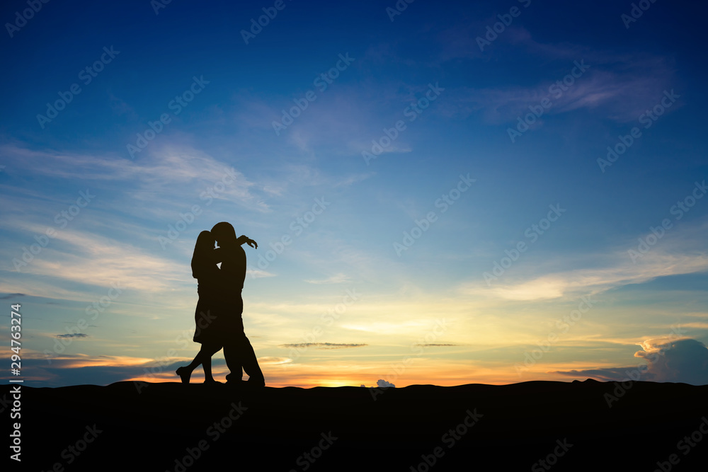 Silhouettes of couple man and woman in nature sunset background. Love concept.