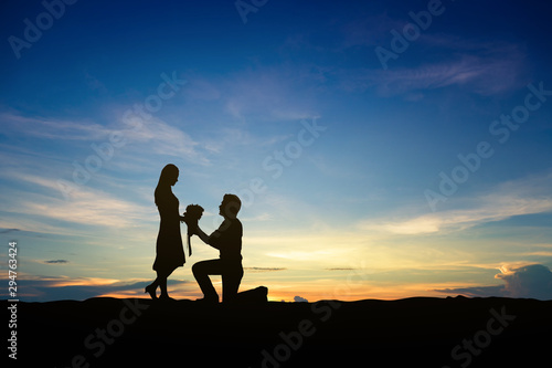 Silhouettes of couple man and woman in nature sunset background. Love concept.