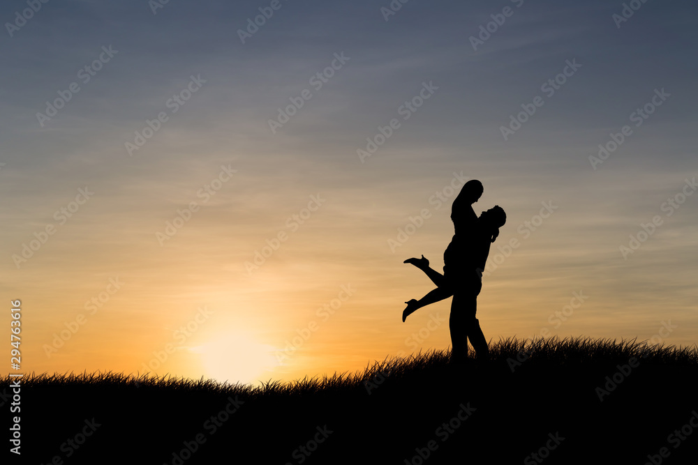 Silhouettes of couple man and woman in nature sunset background. Love concept.