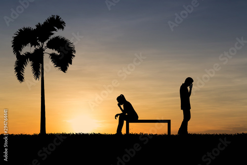 Silhouettes of couple man and woman broken heart at nature sunset. Love concept.