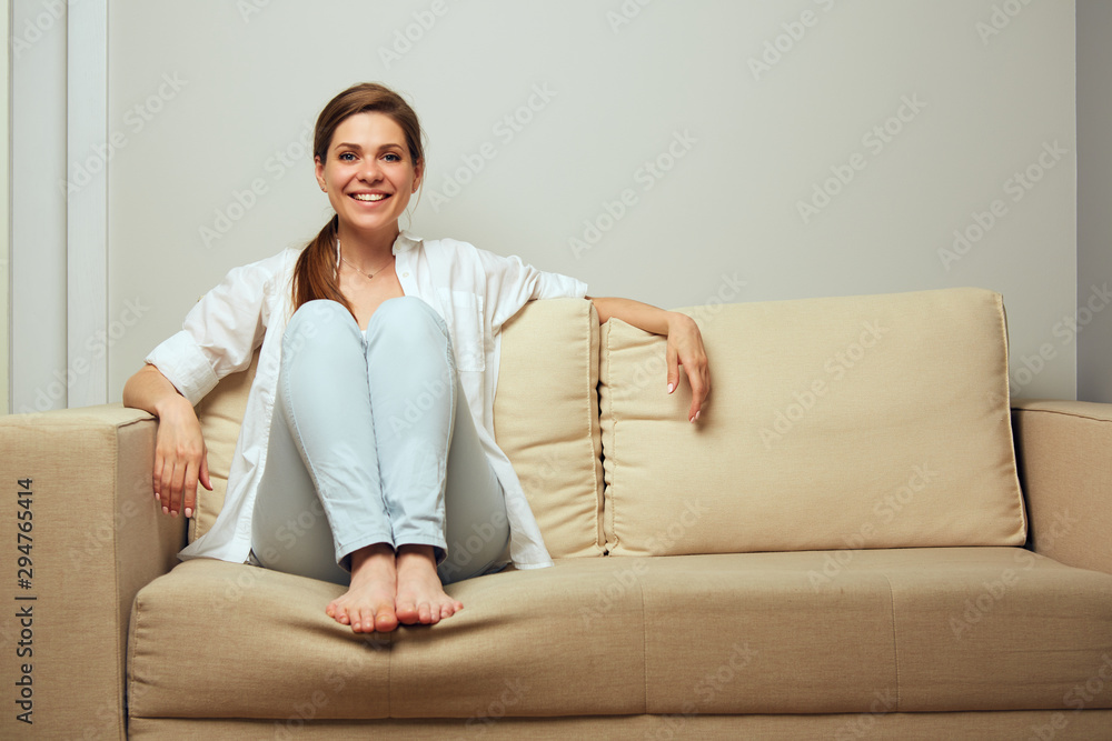 Smiling young woman resting on sofa at home. Smiling young woman resting on sofa at home.