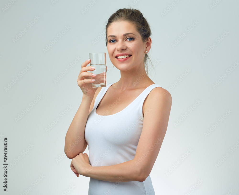 smiling woman in white casual vest holding water glass in front of. smiling woman in white casual vest holding water glass in front of.