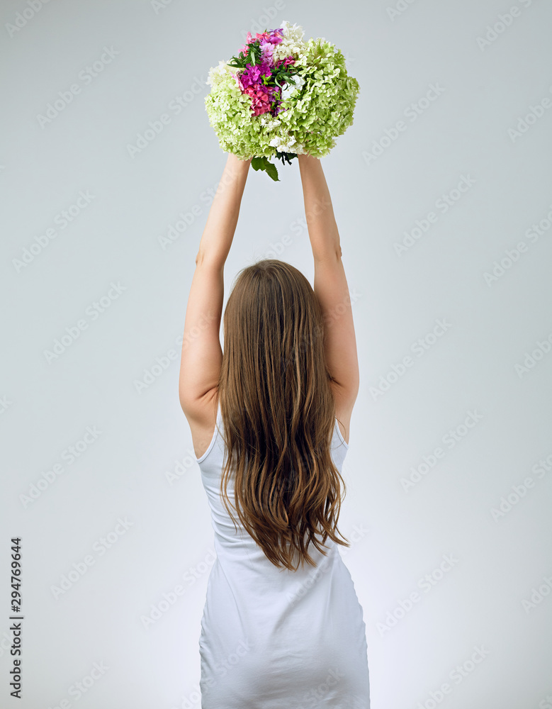 Young woman with raised hand holding flowers. Young woman with raised hand holding flowers.