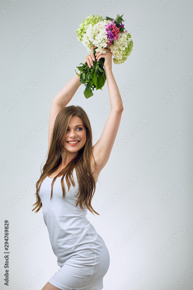 Happy young woman in white dress raised hands up with flowers. Happy young woman in white dress raised hands up with flowers.