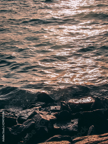 Waves hitting the rocks during sunset at the beach